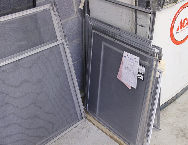 Repaired window screens leaning in the Heights Hardware workshop