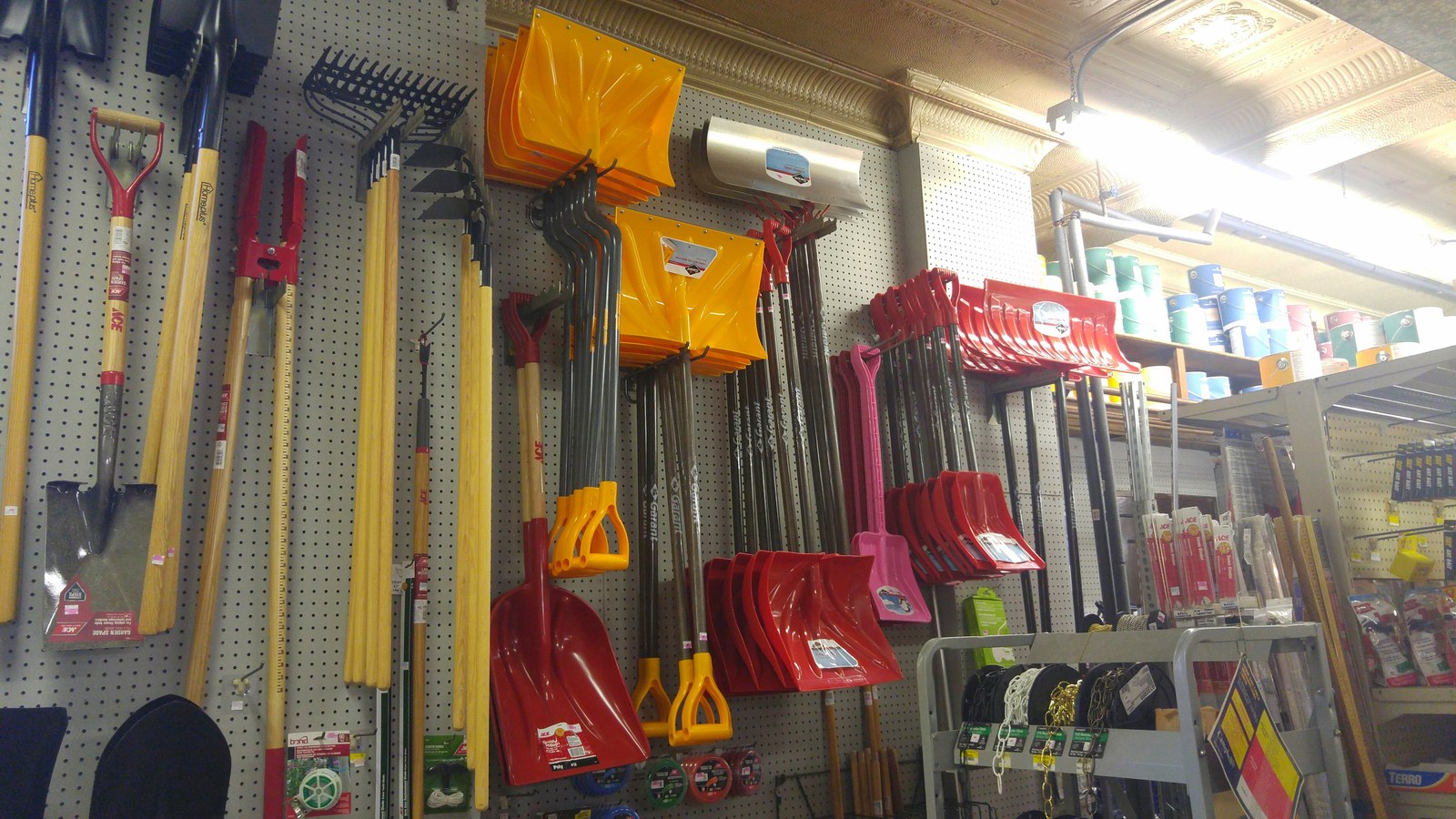 Snow shovels, rakes and garden tools on the wall under the original tin ceiling